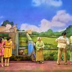 Mei (Victoria Chen), Satsuki (Ami Okumura Jones) standing together in front of a tuk tuk full of their belongings as Tsukiko (Deanna Myers) looks over atTatsuo (Dai Tabuchi) and Hiroshi (Jamie Zubairi) studying a map.